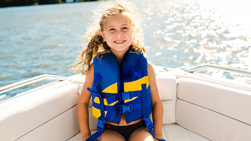 Child wearing a life jacket on a boat